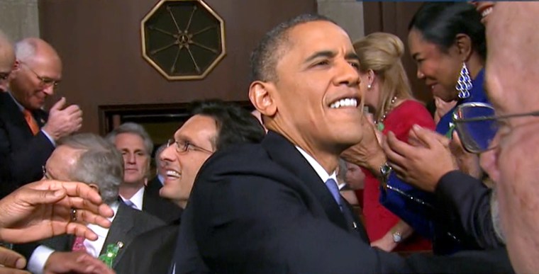 President Barack Obama greets people as he enters the chamber.